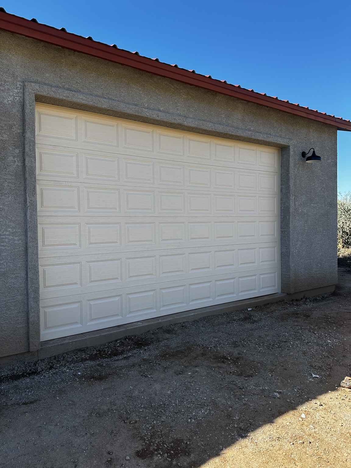 Completed white raised-panel sectional garage door installed in the garage opening.